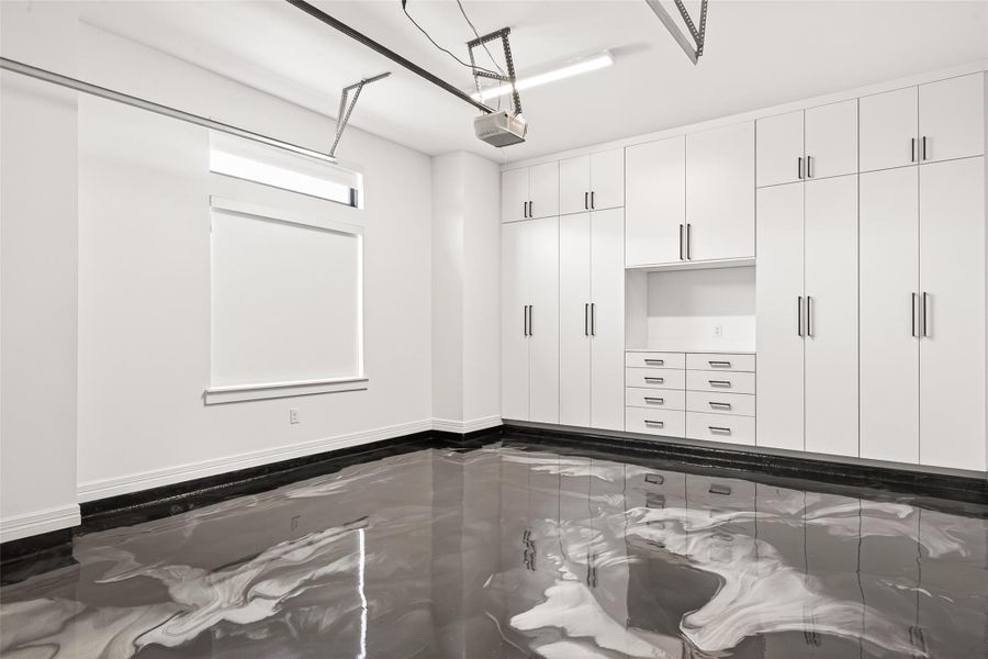 The supersized garage has been customized to accommodate larger vehicles and features built-in cabinetry, epoxy flooring, tankless water heater, water softener, and exceptional storage throughout.