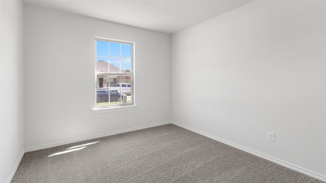 Empty room with dark colored carpet and baseboards