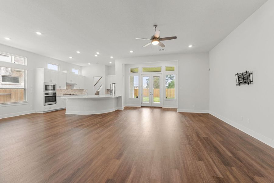 Unfurnished living room featuring healthy amount of natural light, ceiling fan, baseboards, and recessed lighting Unfurnished living room featuring healthy amount of natural light, ceiling fan, baseboards, and recessed lighting