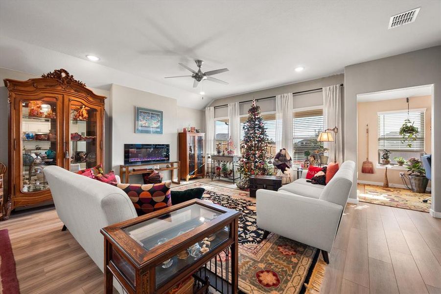 Living room featuring wood finished floors, a ceiling fan, recessed lighting, and vaulted ceiling Living room featuring wood finished floors, a ceiling fan, recessed lighting, and vaulted ceiling