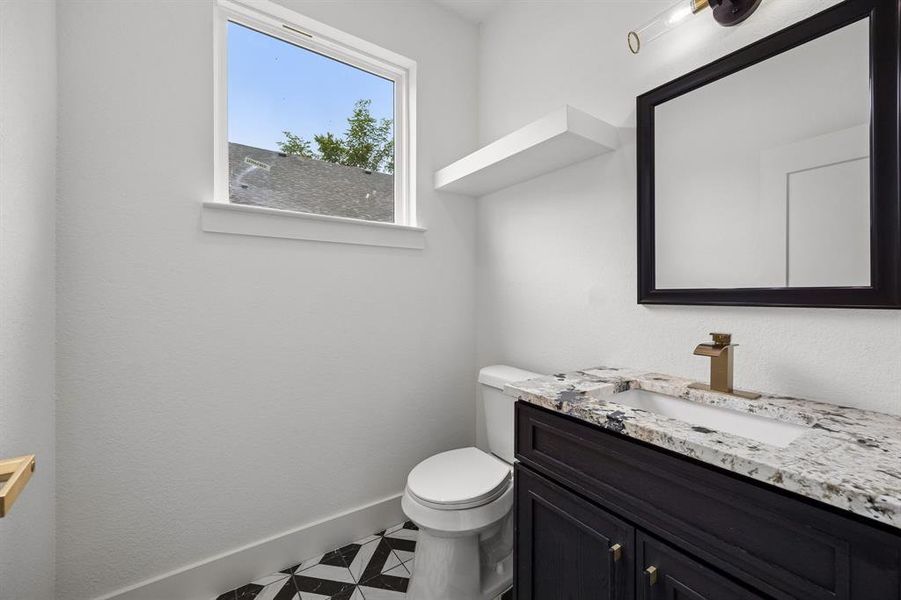 Contemporary bathroom featuring a dark wood-finish vanity with a stone countertop, a rectangular undermount sink, and a gold-tone faucet Contemporary bathroom featuring a dark wood-finish vanity with a stone countertop, a rectangular undermount sink, and a gold-tone faucet