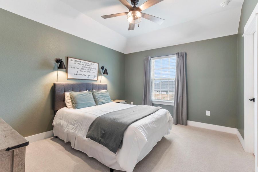 This bright bedroom features a cozy bed with soft green and white decor, complemented by a ceiling fan and ample natural light from the window. This bright bedroom features a cozy bed with soft green and white decor, complemented by a ceiling fan and ample natural light from the window.