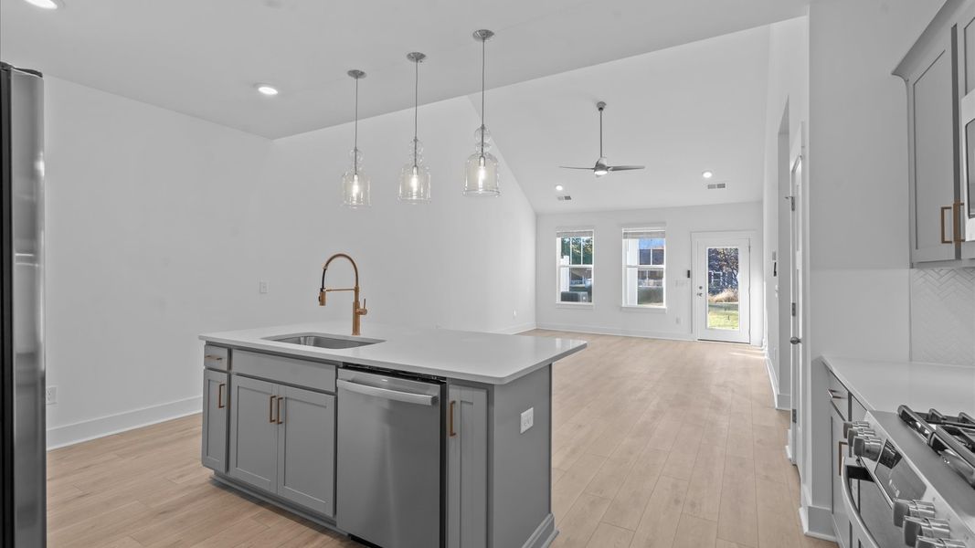 Accomplished kitchen design featuring pendant lighting above a statement island for both prep and gathering