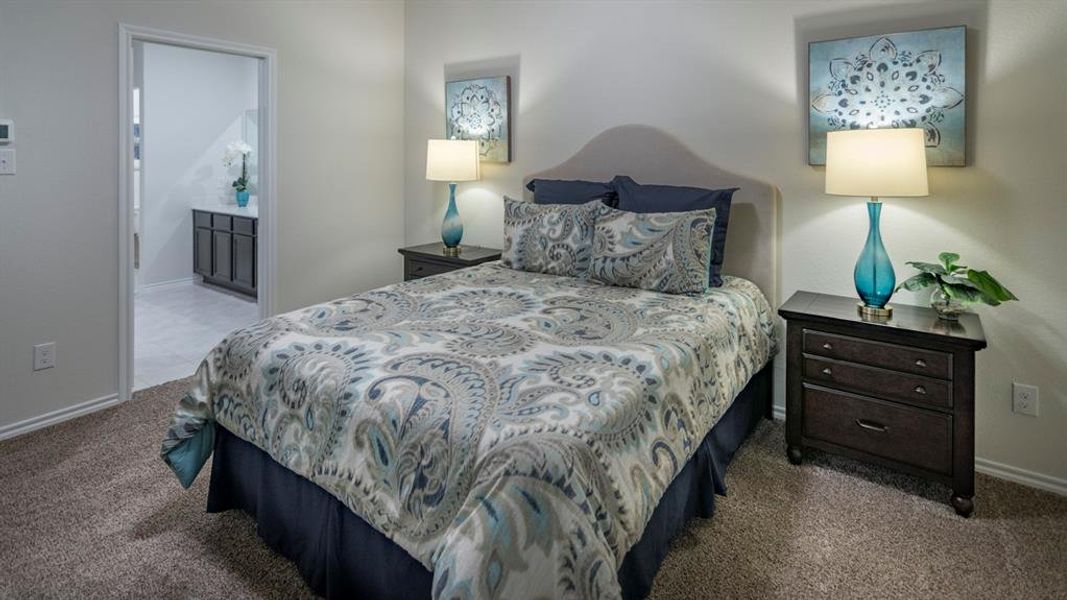 Bedroom with dark colored carpet and connected bathroom