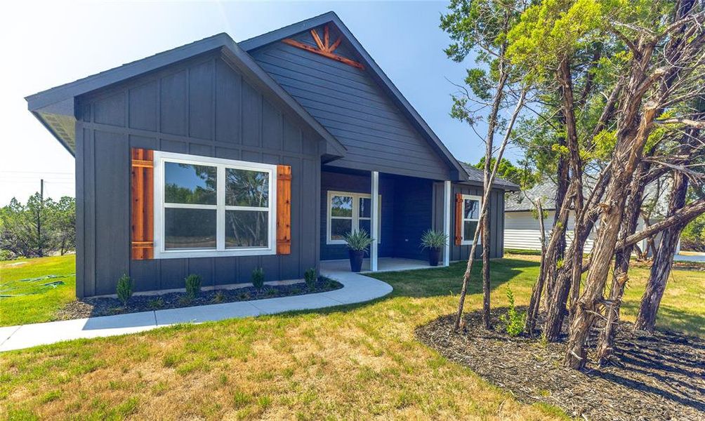 View of front of home featuring board and batten siding, a front yard, and covered porch View of front of home featuring board and batten siding, a front yard, and covered porch