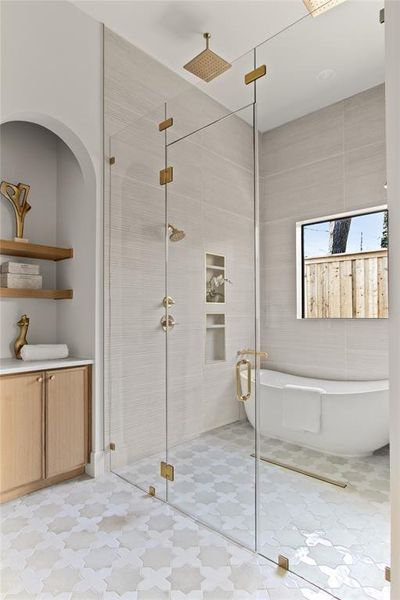 Glass-enclosed shower with gold-tone fixtures and a rainfall showerhead