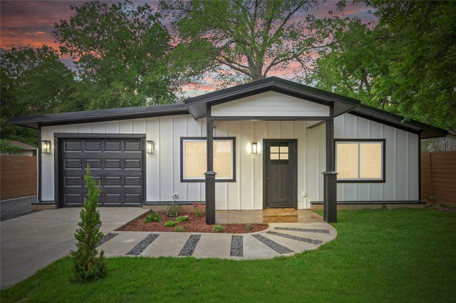 View of front of house featuring board and batten siding, an attached garage, and concrete driveway