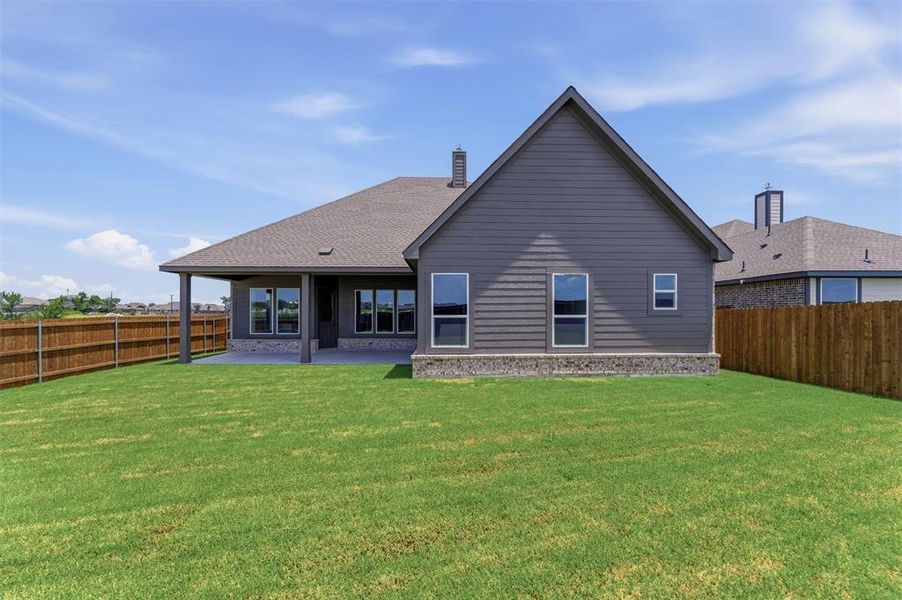 Expansive rear yard featuring a manicured lawn and a wooden privacy fence Expansive rear yard featuring a manicured lawn and a wooden privacy fence