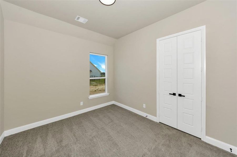 Unfurnished bedroom featuring baseboards and light carpet