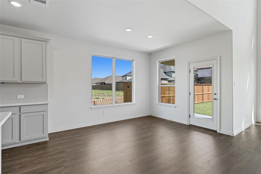 Unfurnished dining area with dark wood-style flooring and recessed lighting Unfurnished dining area with dark wood-style flooring and recessed lighting