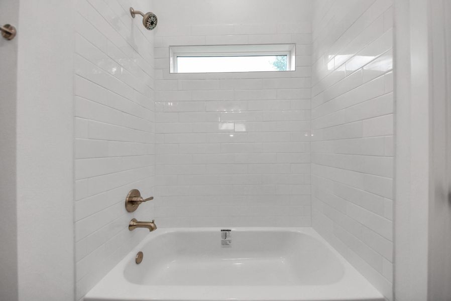 Primary bath features tub/shower combination with natural light Primary bath features tub/shower combination with natural light