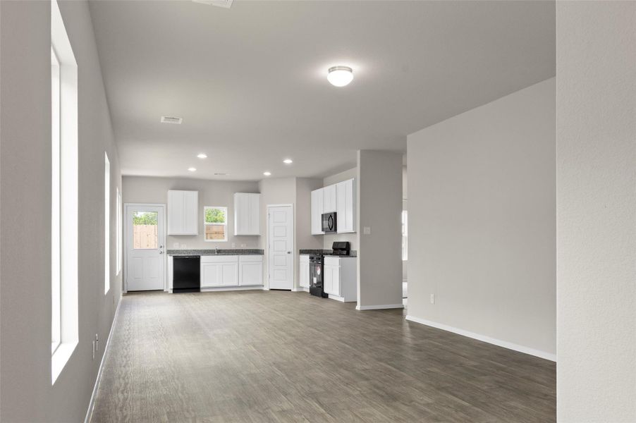 Unfurnished living room with dark wood-type flooring and recessed lighting Unfurnished living room with dark wood-type flooring and recessed lighting