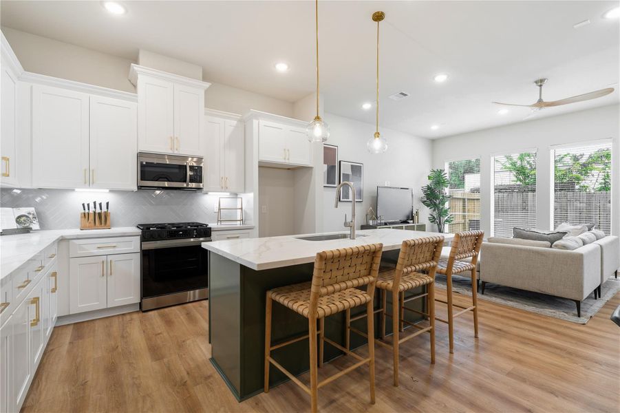 A kitchen that balances statement and simplicity. The accent island draws you in, while layered finishes like brass accents, herringbone tile, and warm lighting create a space that feels both elevated and inviting. A kitchen that balances statement and simplicity. The accent island draws you in, while layered finishes like brass accents, herringbone tile, and warm lighting create a space that feels both elevated and inviting.