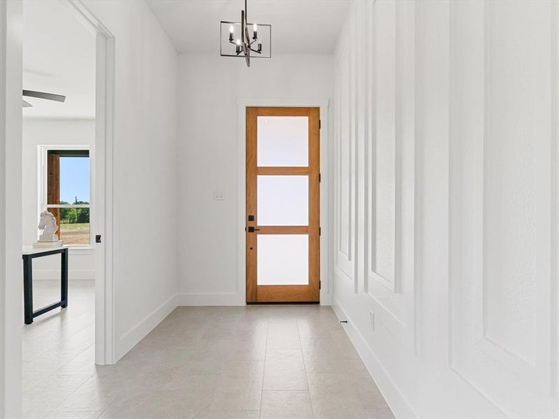 Entryway featuring a chandelier and baseboards