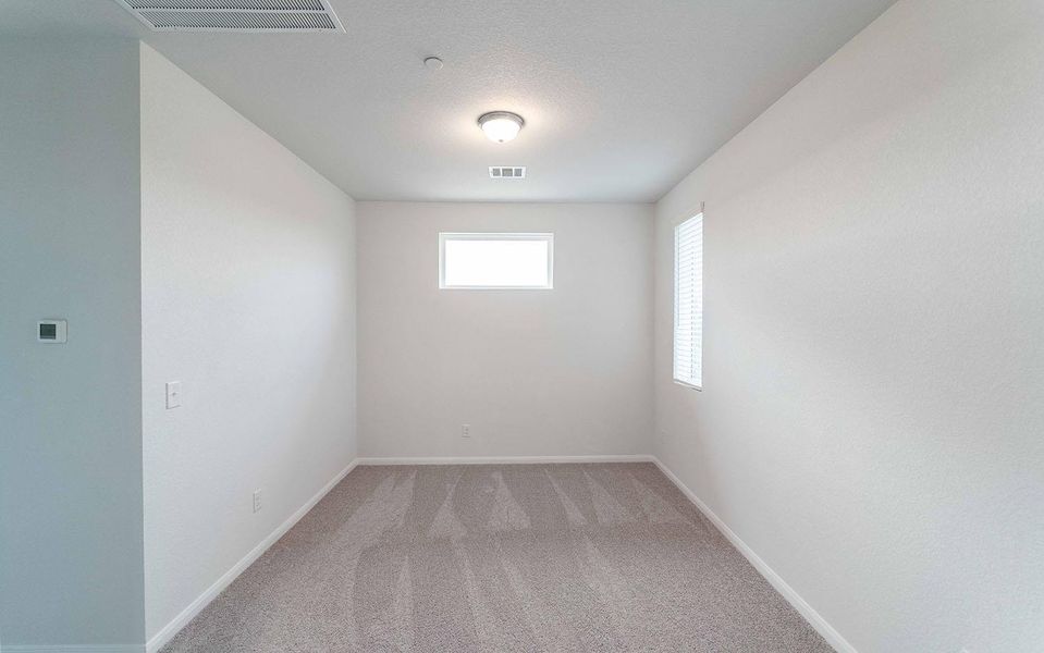 Unfurnished room featuring light carpet and baseboards