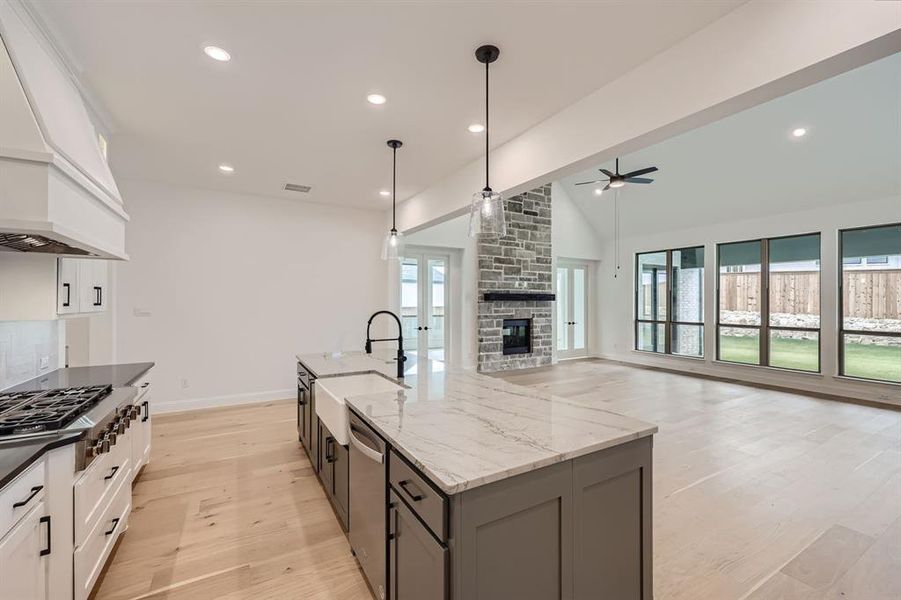 Kitchen with sink, white cabinetry, a kitchen island with sink, and plenty of natural light