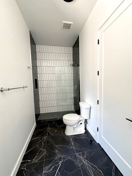 Full bathroom featuring baseboards, visible vents, a stall shower, toilet, and marble finish floor