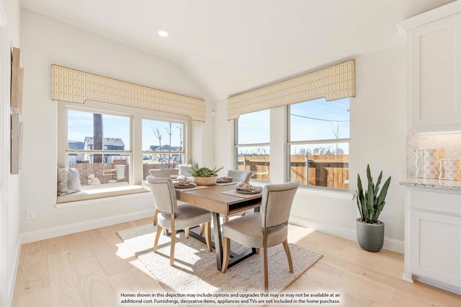 Bright dining area with wood table, four chairs, window seat, and light hardwood floors Bright dining area with wood table, four chairs, window seat, and light hardwood floors