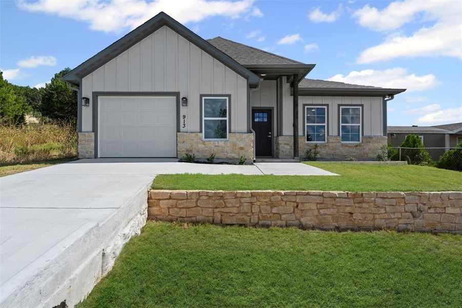 View of front of home featuring board and batten siding, stone siding, concrete driveway, and a garage View of front of home featuring board and batten siding, stone siding, concrete driveway, and a garage