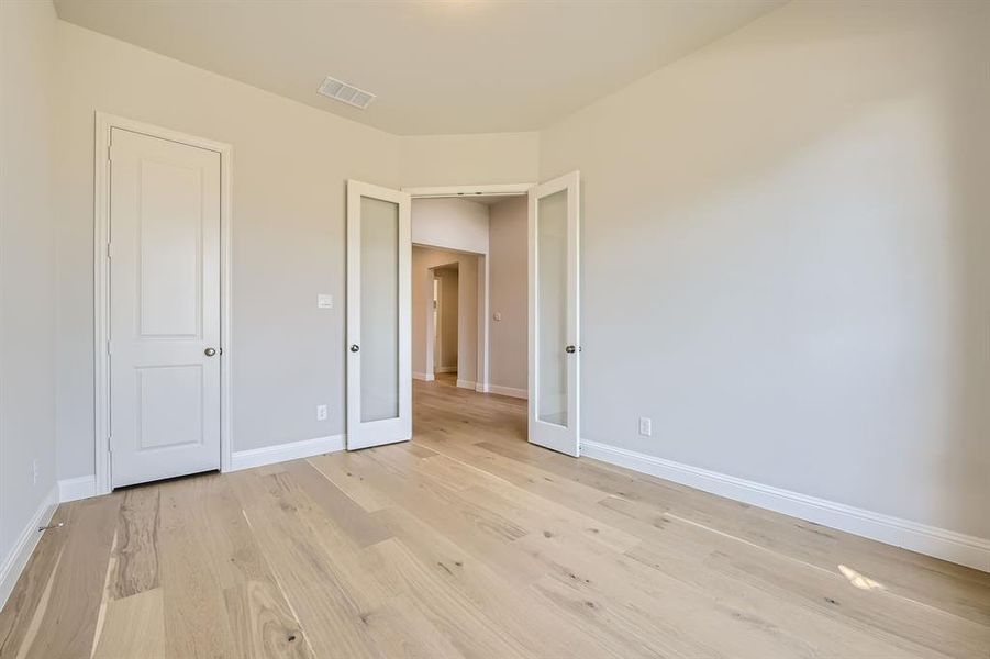 Unfurnished bedroom with light hardwood / wood-style flooring