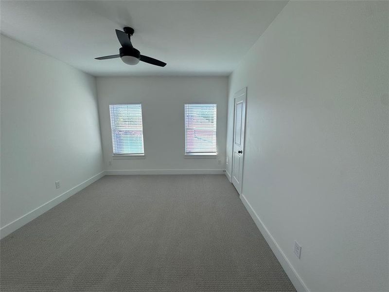 Spare room featuring ceiling fan and light colored carpet