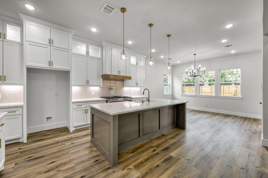 The chef’s dream kitchen features a large kitchen island with quartz countertops, a double oven/range, drawer microwave and stainless steel dishwasher. The chef’s dream kitchen features a large kitchen island with quartz countertops, a double oven/range, drawer microwave and stainless steel dishwasher.