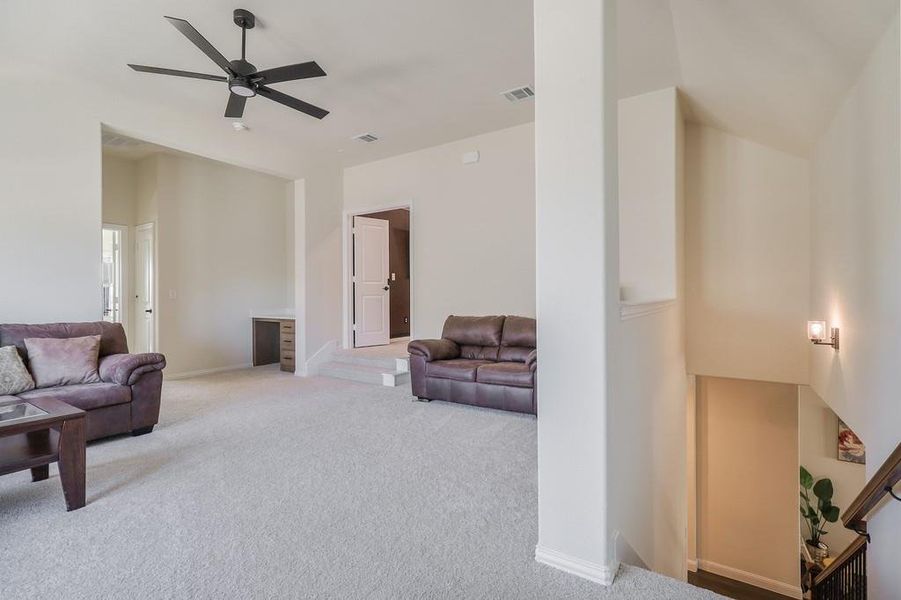Living area with carpet and a ceiling fan