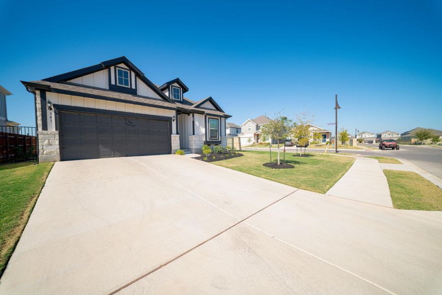 View of front of house with a residential view, stone siding, driveway, board and batten siding, and an attached garage View of front of house with a residential view, stone siding, driveway, board and batten siding, and an attached garage