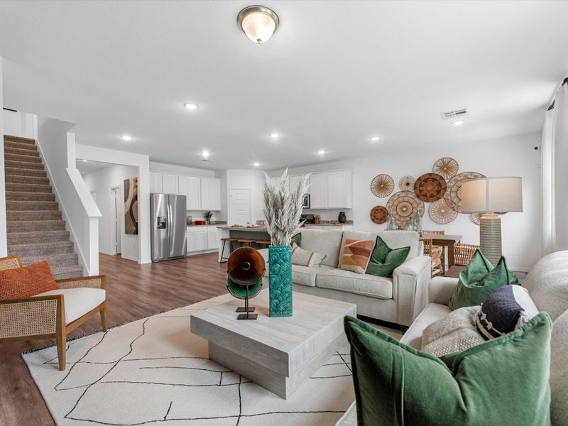 A living room with a staircase. A living room with a staircase.