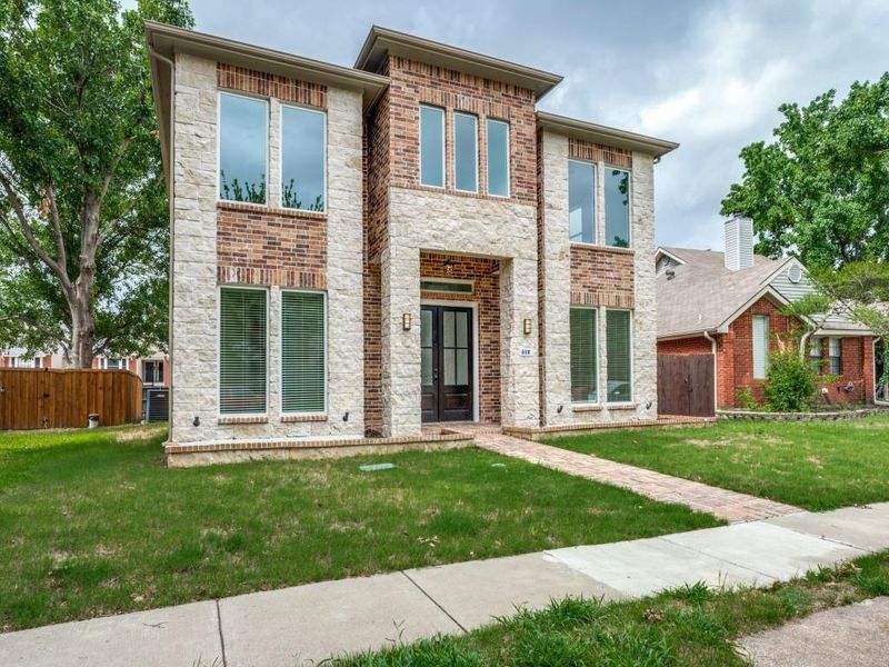 Contemporary home with french doors, stone siding, and brick siding