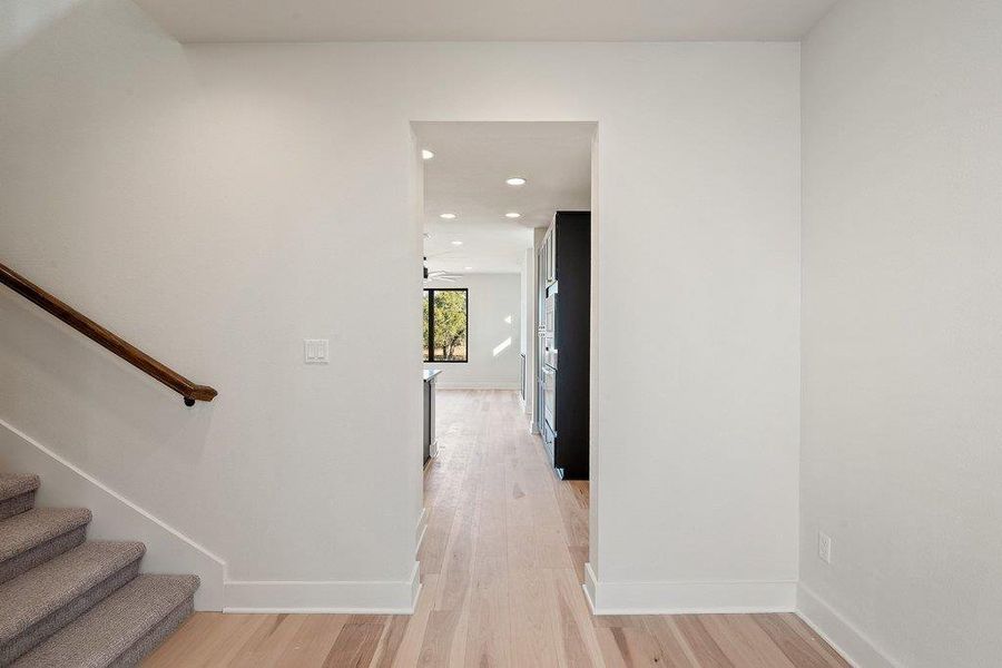 Hall featuring light wood-style floors, recessed lighting, and stairs