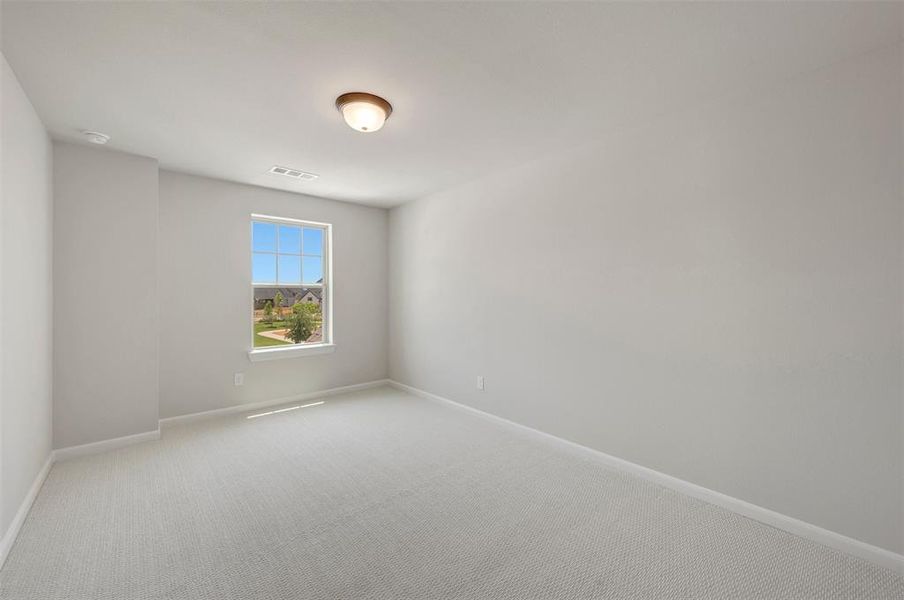 Neutral-toned room featuring a single window, light gray carpeting, and white baseboards