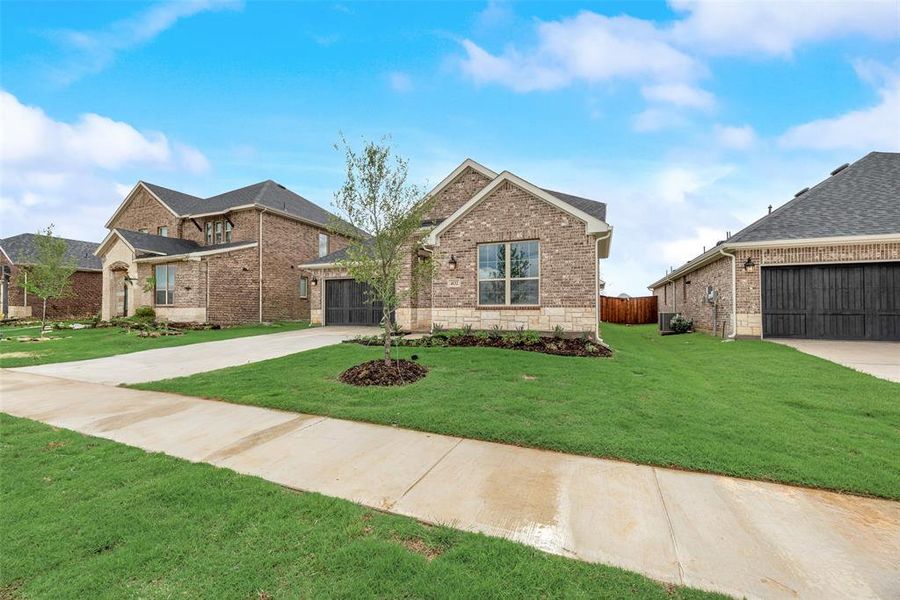 Front exterior of a new home in Spiritas Ranch, Little Elm, TX, highlighting curb appeal (Image 1). Front exterior of a new home in Spiritas Ranch, Little Elm, TX, highlighting curb appeal (Image 1).