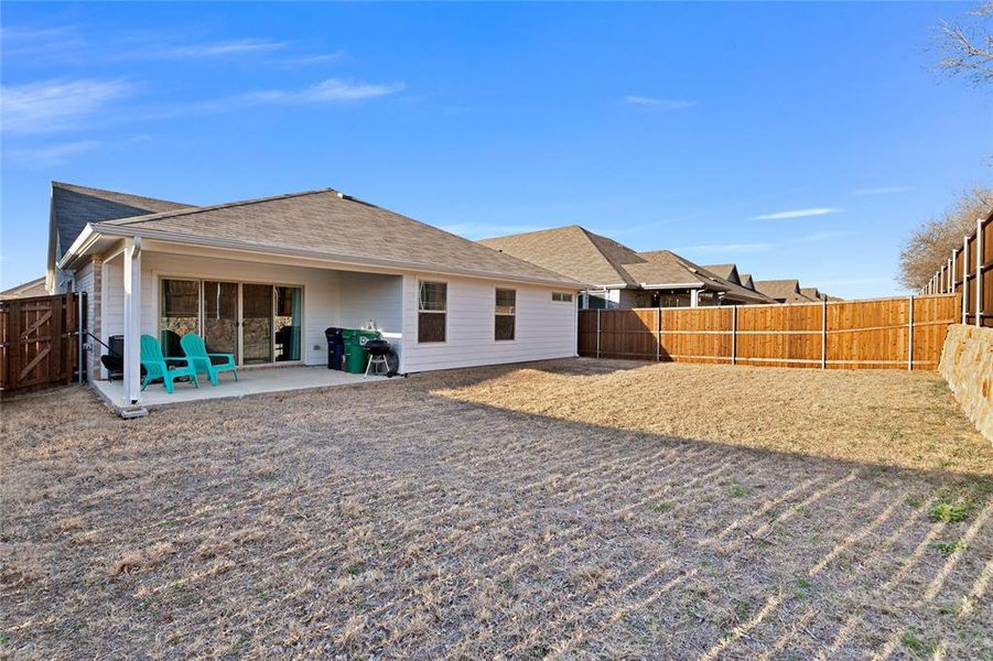 Back of house with a patio, a fenced backyard, and a shingled roof