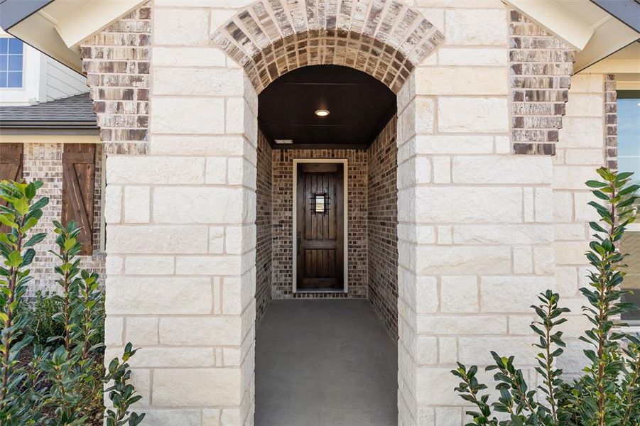 Doorway to property with brick siding and stone siding