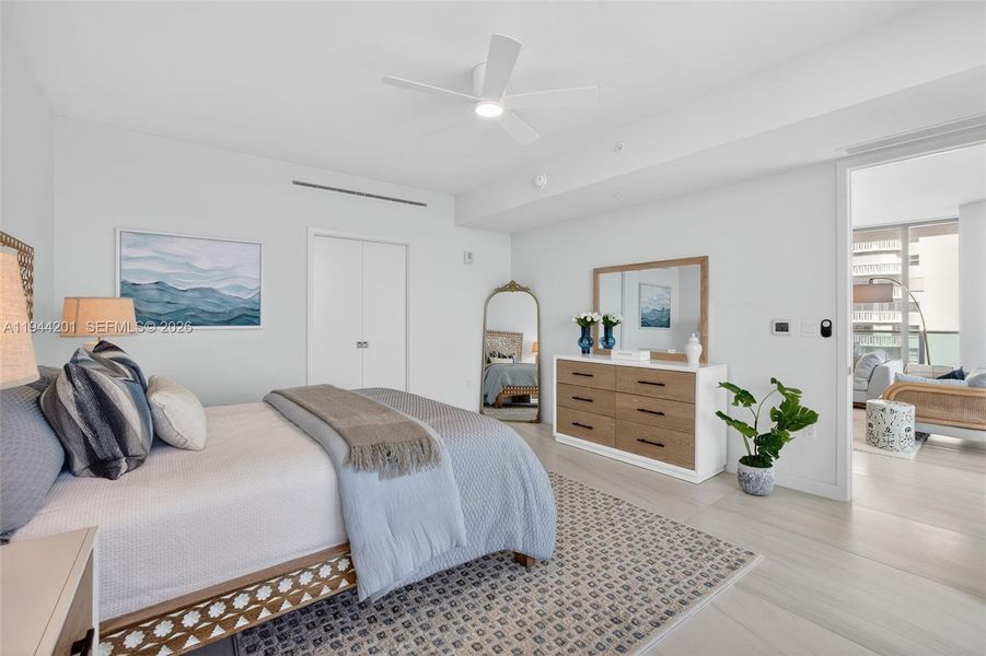 Spacious primary suite with floor to ceiling glass, terrace access, two walk in closets, and spa inspired bath.