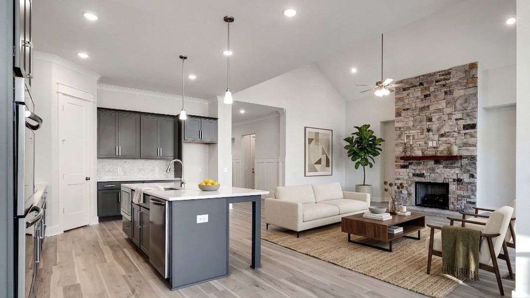 Virtually staged living room with stone fireplace near kitchen