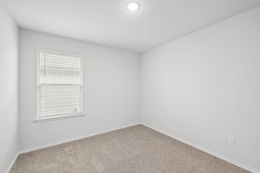 Neutral-toned wall-to-wall carpeting complements the light wall color in this room