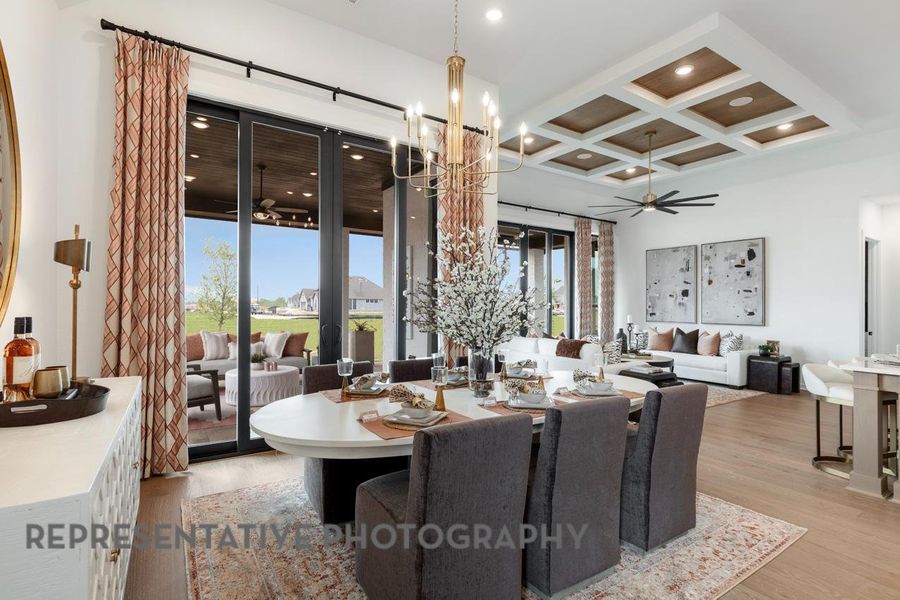 Dining room with recessed lighting, coffered ceiling, light wood-style floors, beam ceiling, and ceiling fan with notable chandelier