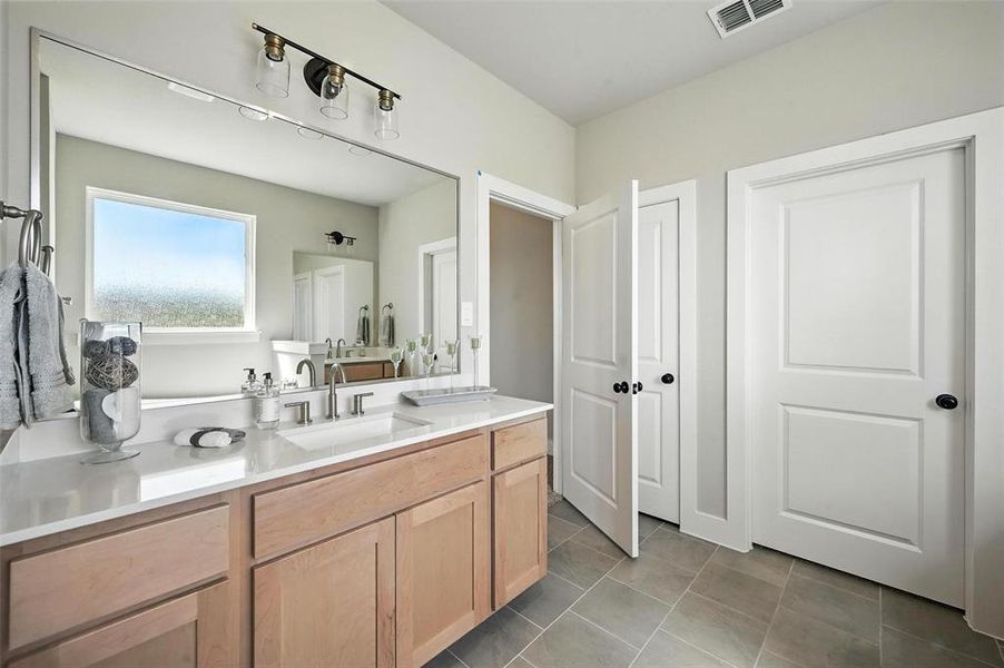 Bathroom featuring vanity and dark tile patterned floors