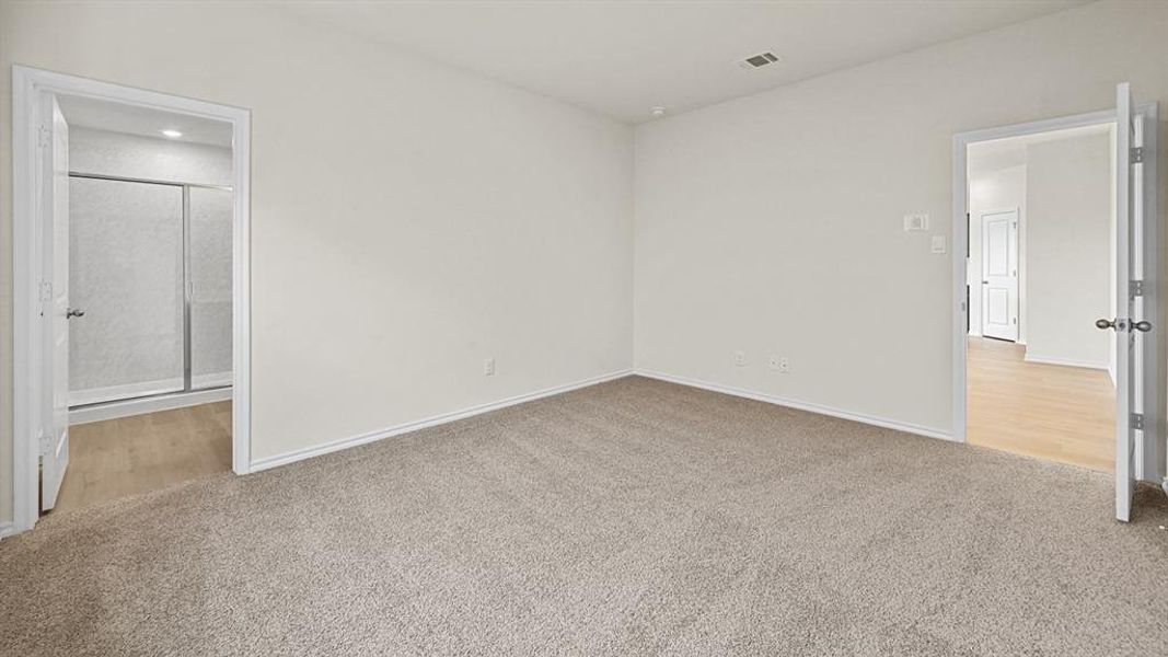 Unfurnished bedroom featuring light carpet and ensuite bath