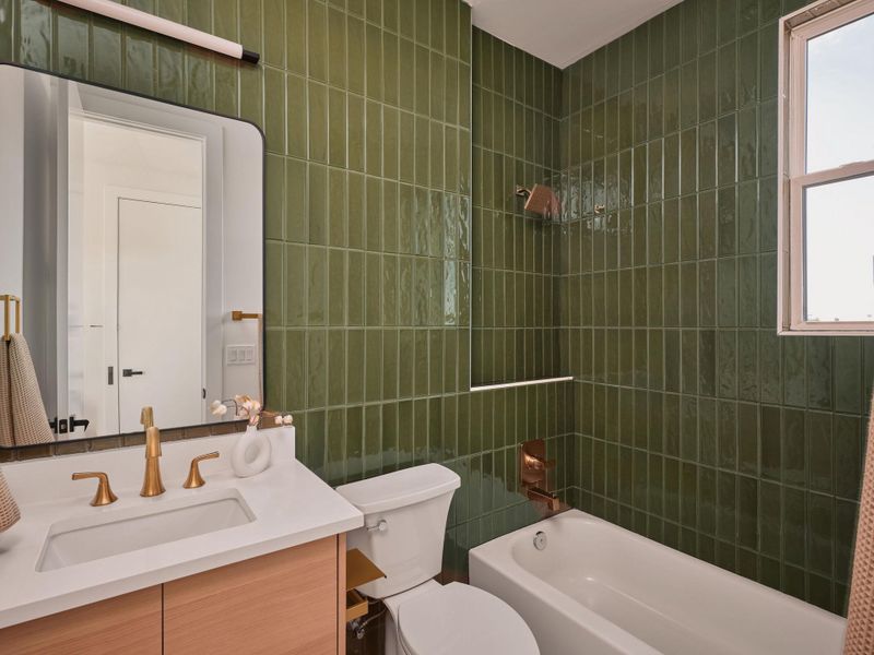 Full bathroom featuring tile walls, vanity, and shower / tub combination