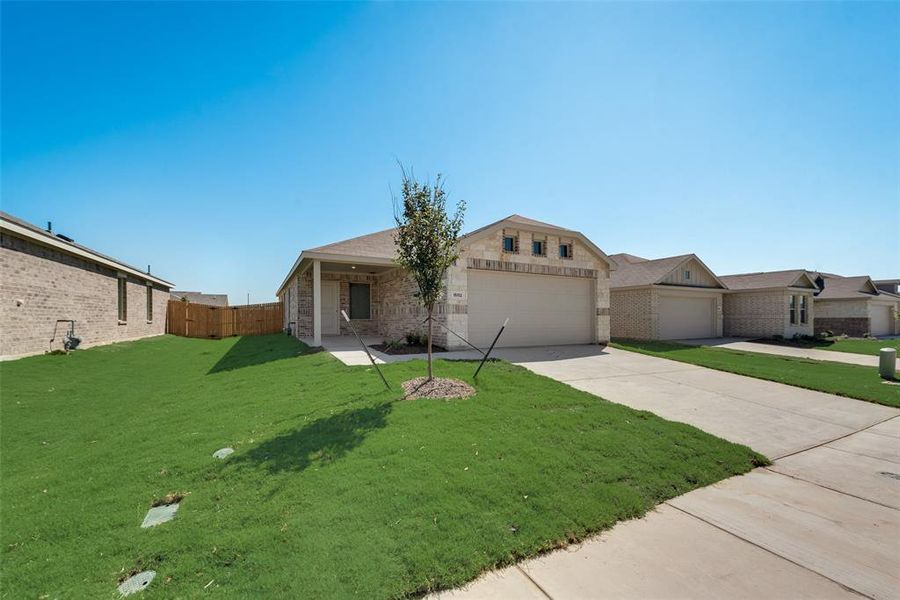 Ranch-style house featuring a front lawn and a garage