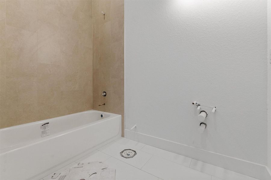 Bathroom with tub / shower combination and tile patterned flooring Bathroom with tub / shower combination and tile patterned flooring