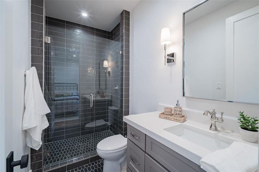 Bathroom featuring vanity, an enclosed shower, and toilet