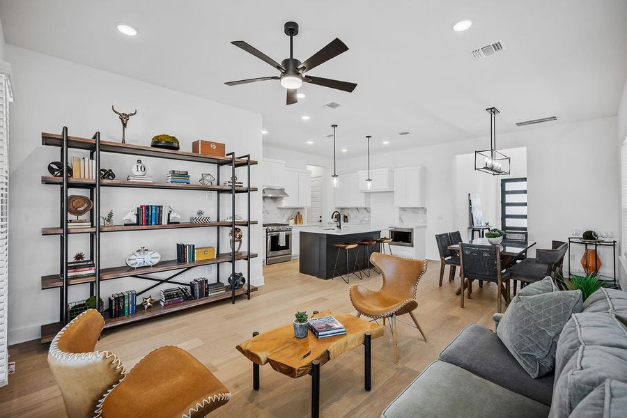 Open floor plan from entry with one of two living spaces, dining area and kitchen with sit at island.