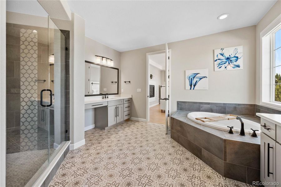 Primary Bathroom with Custom Tiling, Custom Shower, Bathtub, and Dual Vanities.