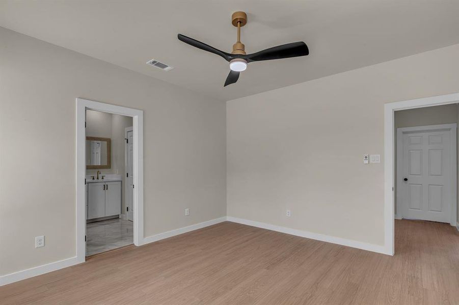 Spare room with ceiling fan, sink, and light wood-type flooring