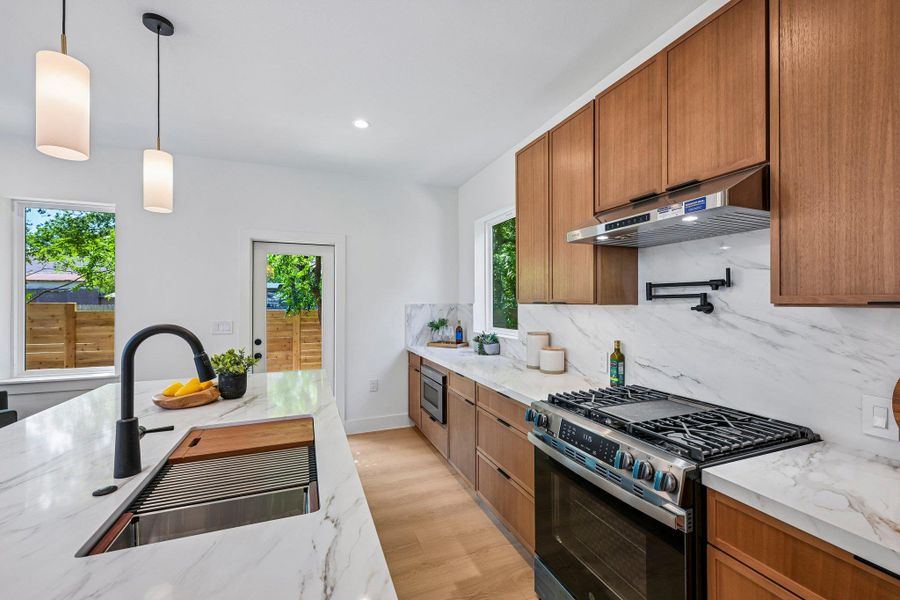 Culinary adventures await in this naturally illuminated kitchen, with sleek quartz countertops and a convenient pot filler. Culinary adventures await in this naturally illuminated kitchen, with sleek quartz countertops and a convenient pot filler.