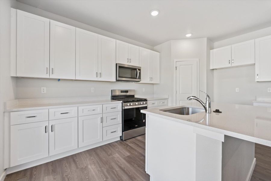 A kitchen with white cabinets.